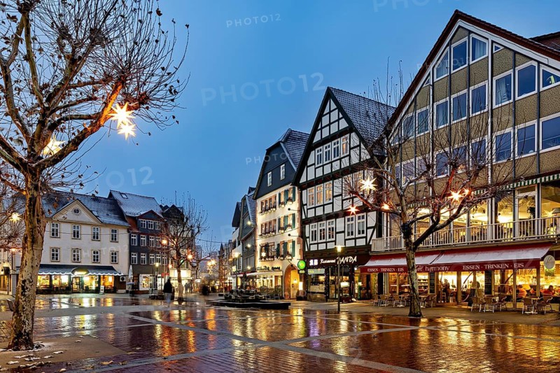 Street scene with illuminated half-timbered houses and winter decoration at dusk, view of the city center of Bad Hersfeld