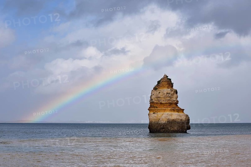 Rock formation in the ocean with rainbow, Praia do Camilo, Lagos, Algarve, Portugal