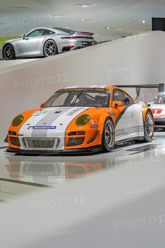 Orange-white Porsche racing car in an exhibition hall, Porsche Museum, Stuttgart, Germany