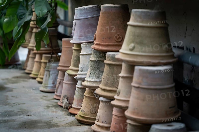 Different colored clay pots, terracotta pots, are stacked in a greenhouse, Palermo Botanical Garden or Orto Botanico, Palermo, Sicily, Italy