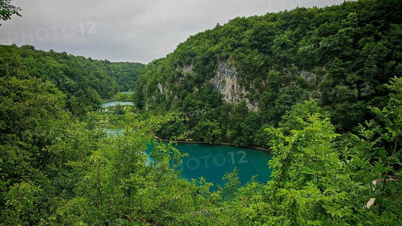 View of a quiet lake surrounded by wooded hills, Plitvice Lakes National Park, Croatia