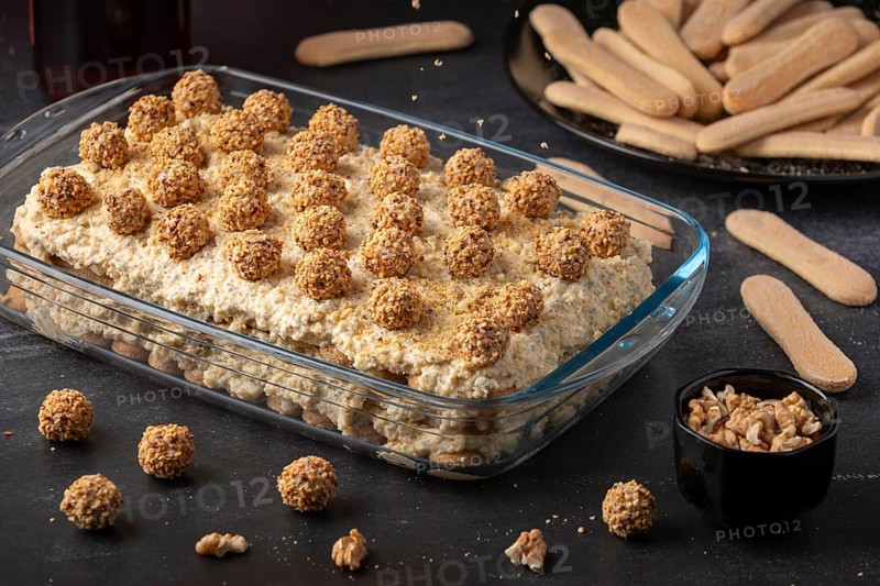 Ready tiramisu with nut balls surrounded by bisque and nuts