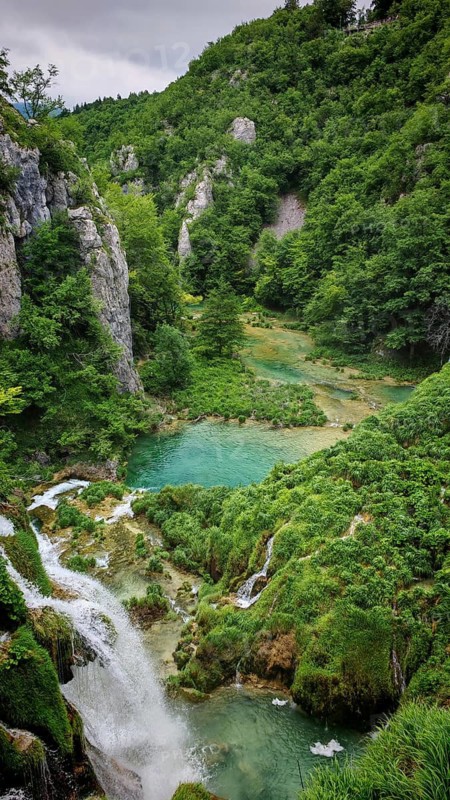 A small valley with a clear lake and surrounding vegetation, Plitvice Lakes National Park, Croatia