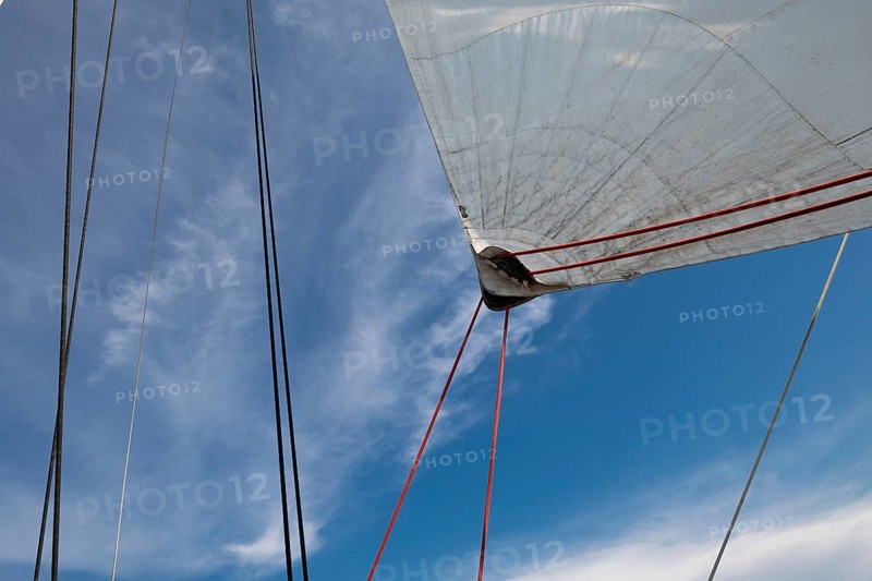 View of sails and ropes of a sailing ship against a blue cloudy sky, Aeolian or Lipari Islands, Sicily, Southern Italy, Italy