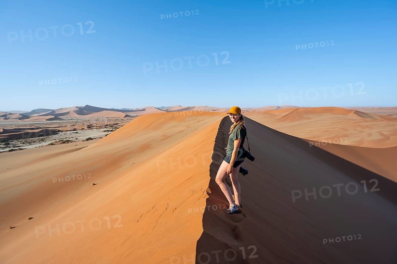 Female hiker on a sand dune in the Namib Desert, Namib Naukluft Park, Namibia