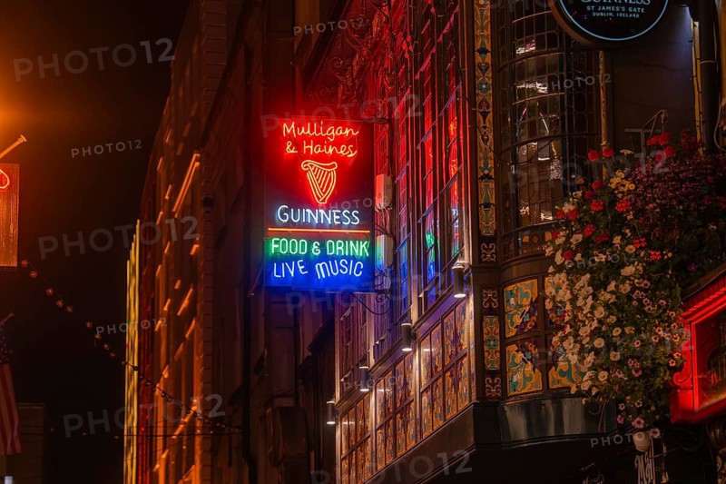 Colourful neon signs of a pub glow at night in a lively atmosphere, Nightlife, Dublin, Ireland