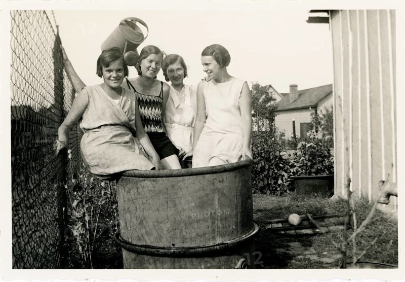 Bathing, swimwear, leisure, summer, woman, group of woman sitting laughing on an outdoor metal bin, allotment garden, watering can, around 1930