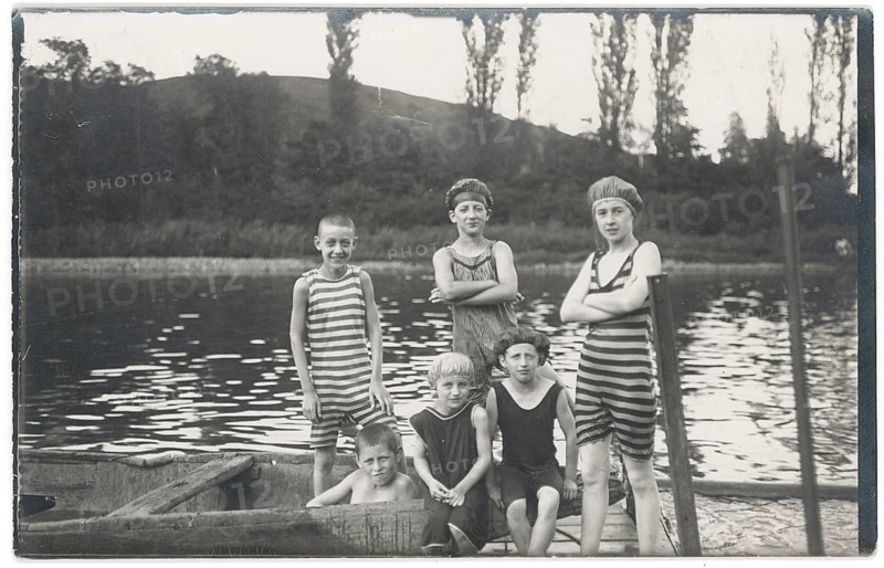 Bathing, swimwear, children, leisure, fun, summer, lake, boat, children in striped bathing suits on the shore of a lake in front of a wooded range of hills, around 1920