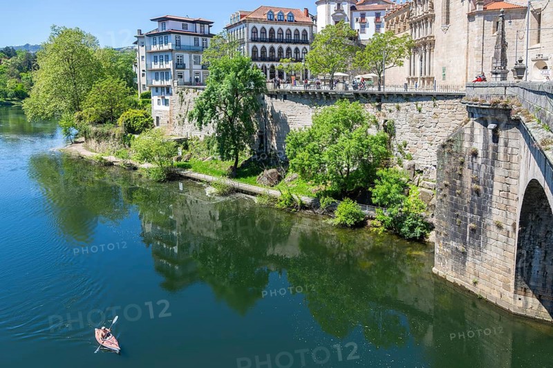 Person kayaking in River Tamega next to historic town centre, Amarante, Portugal