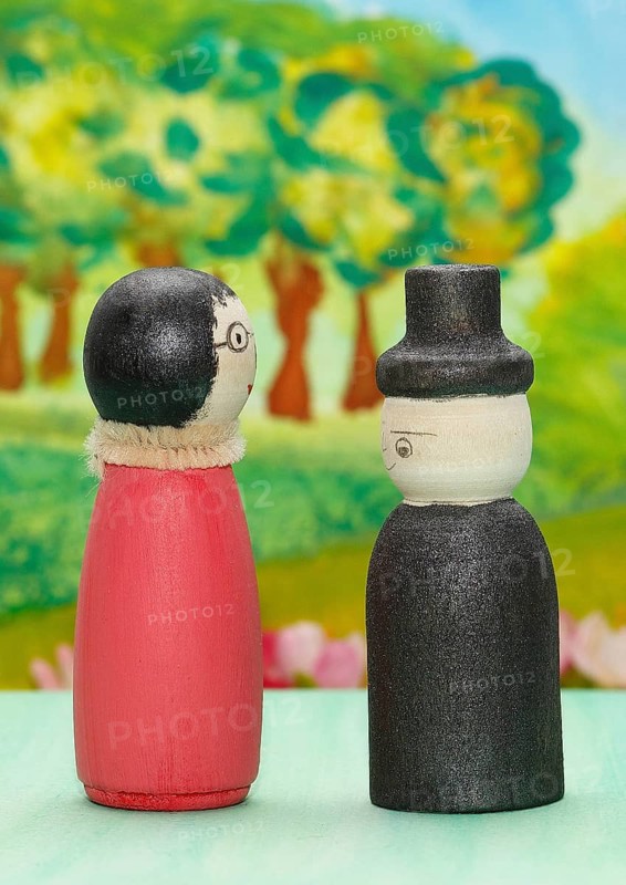 Funny painted wooden cone man and woman in front of a colourful painted background, North Rhine-Westphalia, Germany