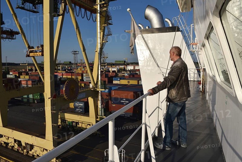 Man, senior, passenger standing on the bridge of a container ship in the port of Riga, Riga, Latvia
