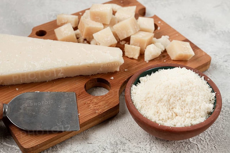 Freshly sliced and grated cheese, parmesan cheese, Gran gusto. Grana padano. on a wooden chopping board, rustic style, no people