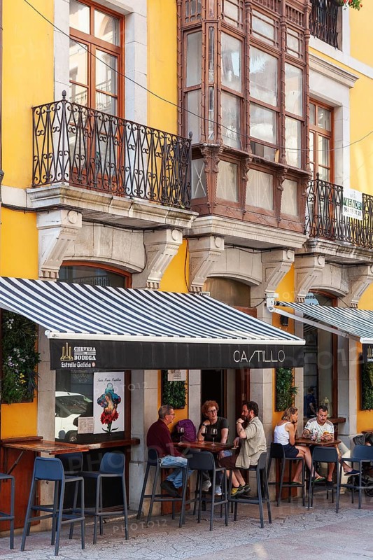 People enjoys the terrace of a bar in a sizzling day, Llanes village, principality of Asturias, Spain
