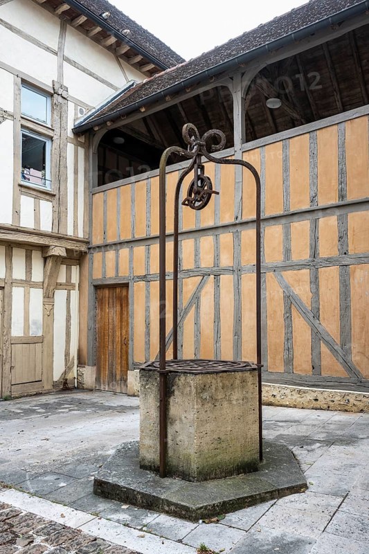 Historic well with delicate wrought iron wheel construction in the old town of Troyes, Aube department, Grand Est region, France