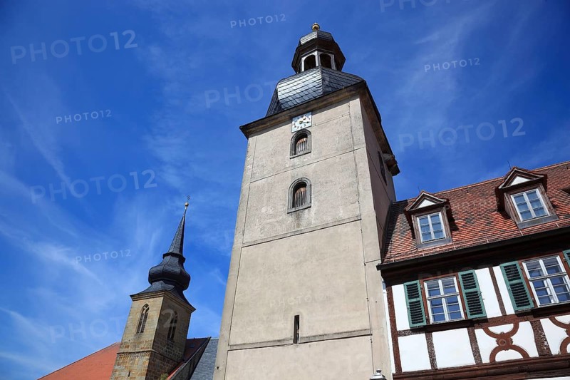 The historic gatehouse with the school tower and the Roman Catholic parish church of St. Peter and Paul in Rattelsdorf, a market in the Upper Franconian district of Bamberg, Bavaria, Germany. The core of the building's tower dates from the 13th century