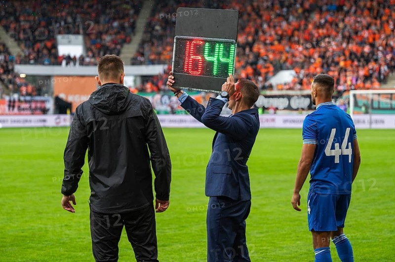Man shows players substitution during football match in Lubin, Poland