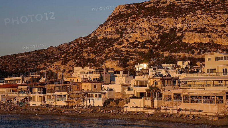Coastline with houses in front of a hill at sunset, quiet atmosphere, Matala, south coast, Crete, Greek Islands, Greece