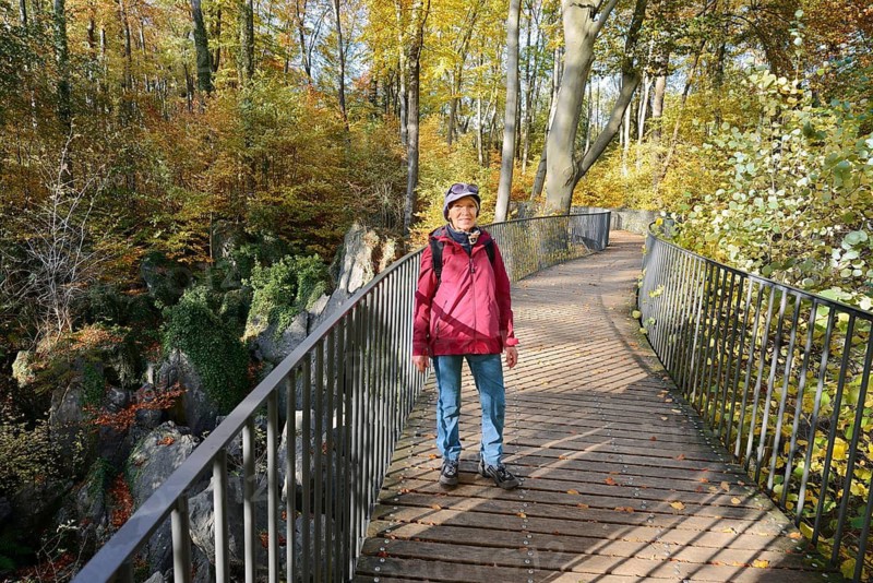 Woman on a footbridge in autumn, Felsenmeer, Hemer, North Rhine-Westphalia, Germany