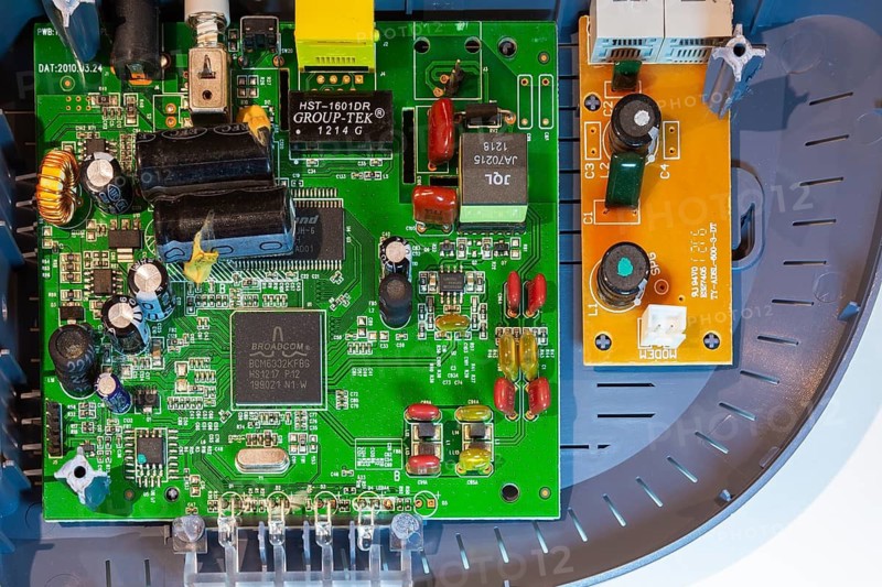 Close-up of printed circuit board with integrated circuits, electronic components inside single port ADSL2+ modem router device on white background, Studio Composition, Quebec, Canada