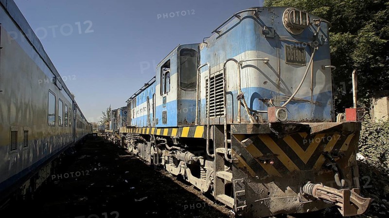 Blue locomotive with worn look on tracks, industrial atmosphere, Dakar railway station, traveling in Senegal
