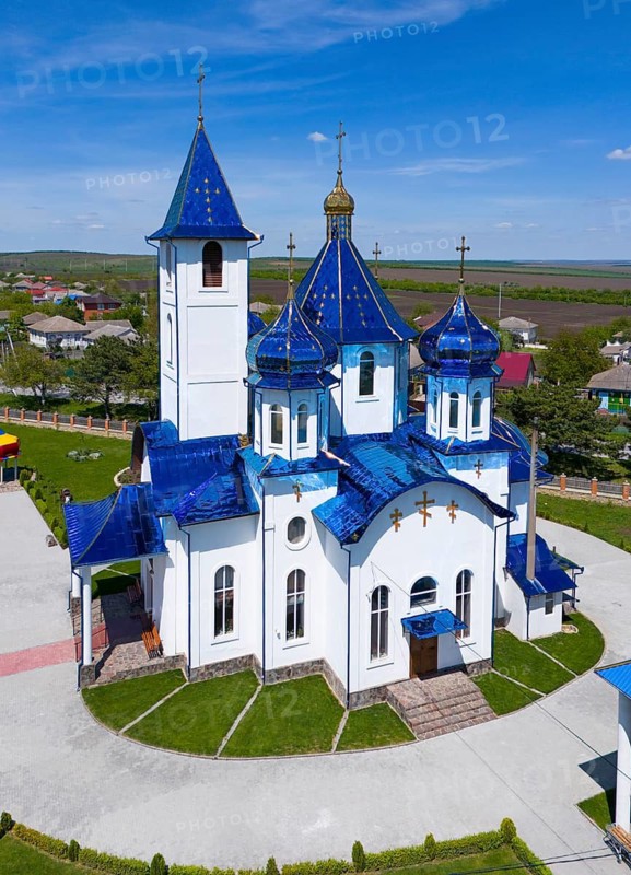 Church building with blue dome and white façade under a sunny sky, aerial view, Church of the Protection of Our Lady, Biserica Acoperamântul Maicii Domnului, Tarigrad, Drochia District, Republic of Moldova, Moldova