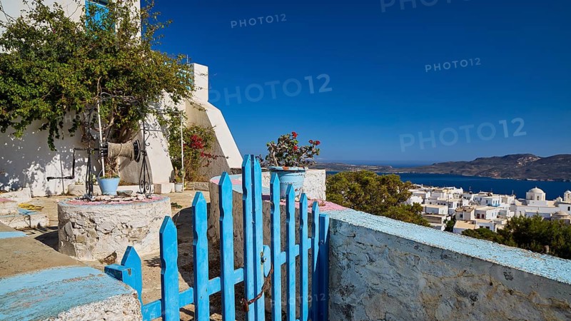 Blue gate and flowers in front of a white house and sea view on a Greek island, church of Panagia of Thalassitra, Panagia Thalassitra, Plaka, main town on Milos, island of Milos, volcanic island, Cyclades, Greek islands, Greece