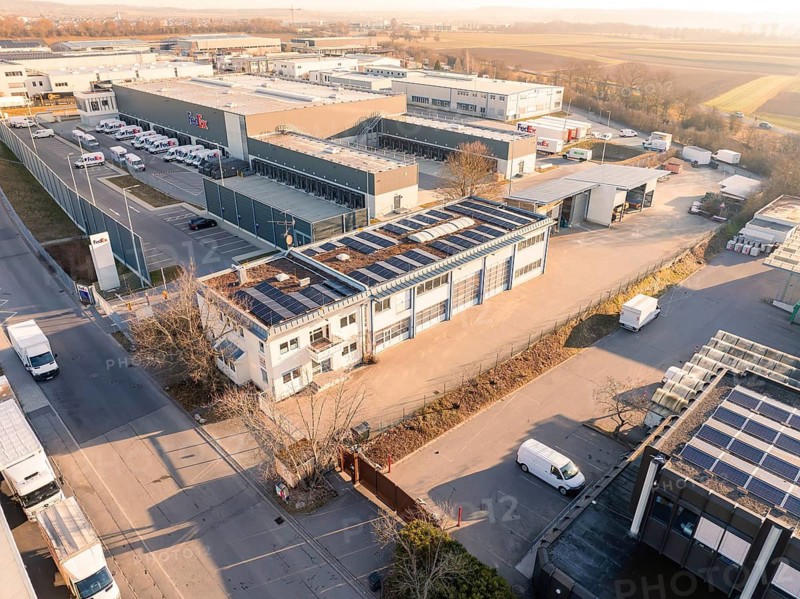 Industrial complex with solar roofs and warehouse buildings, surrounded by roads in the morning, Bauhof, Nufringen, Germany
