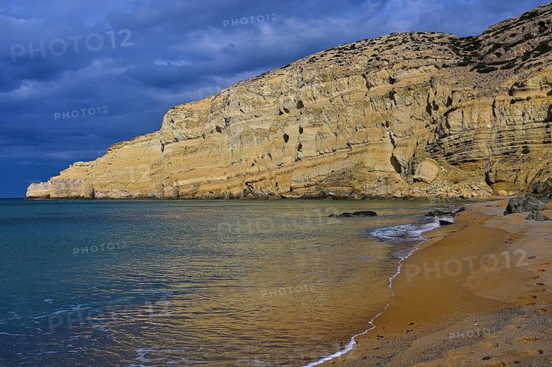 Red Beach, dream beach in the neighboring bay of Matala only accessible on foot, wide coastal landscape with dramatic sky, long-lasting sandy beach and mighty rock face, Matala, Neolithic caves, former hippie paradise, central south coast, Crete, Greek Islands, Greece