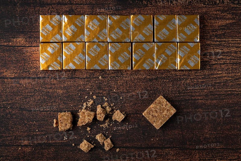 Soup cubes with and without packaging on a wooden table