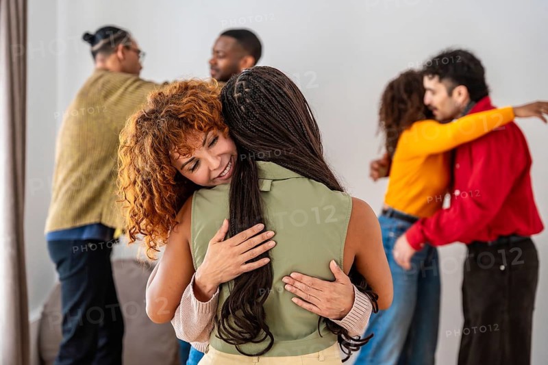 Diverse young people participating in a group therapy session, finding comfort and support while embracing each other, fostering a sense of community and emotional wellness