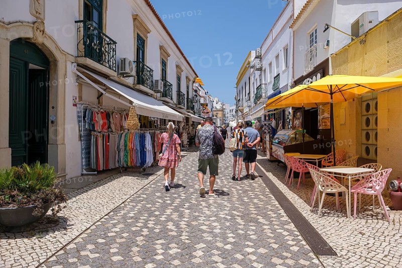 Pedestrian street with cobblestones flanked by historic buildings and shops, Albufeira, Faro, Portugal