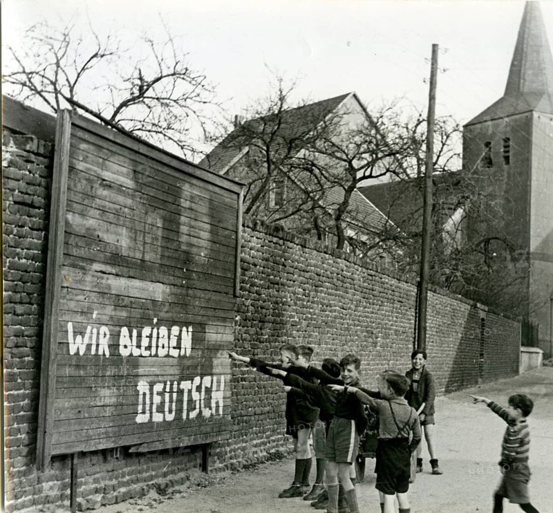 Hinterpommern, we remain German, slogan, 1946 post-war period, children point at a wall with graffiti near a church