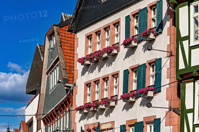 Half-timbered houses in an old town with flowers on the windows and a clear blue sky, historic house facades in the city center of Bad Hersfeld