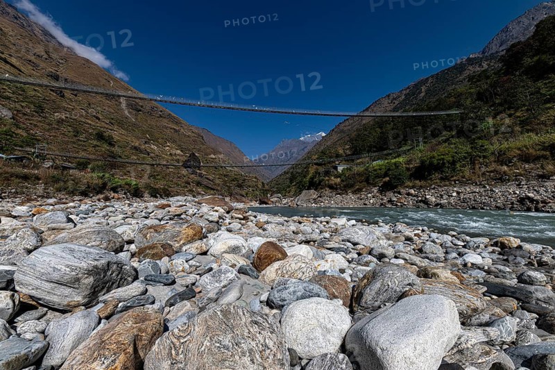 Suspension bridge made of steel cables across river valley, Tsum Valley, Himalayas, Nepal