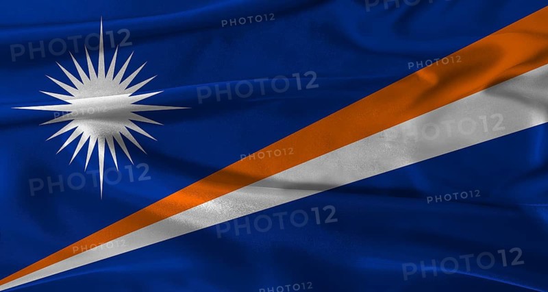 Flag of Marshall Islands with fabric textured background. Close up of National flag of Marshall Islands with realistic texture
