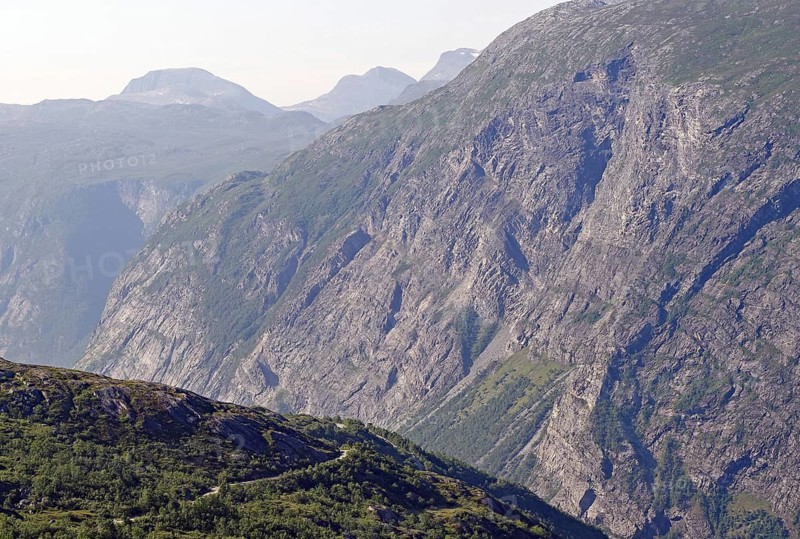 Extensive view of impressive rock formations and green valleys and a gravel road in the fells, Eikesdalen, Aursjövegen, More og Romsdal, Norway