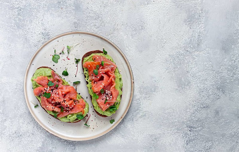 Breakfast, Sandwiches with smoked salmon and avocado, on dark rye bread, with microgreens, on a marble table, homemade, no people
