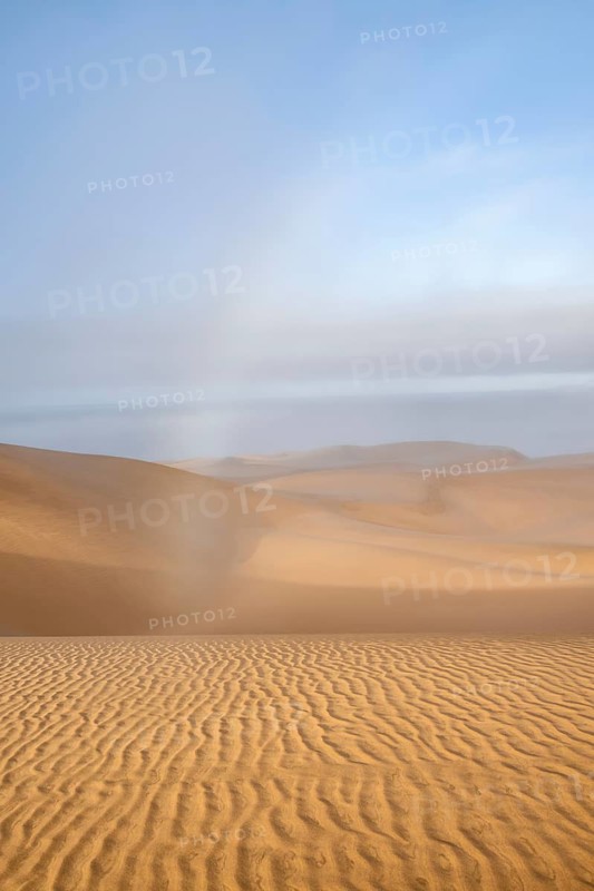 Rainbow in coastal fog in morning, sand dunes in morning light, Sandwich Harbour, Namib Naukluft Park, Namib Desert, Namibia