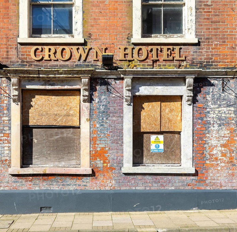 Historic Crown Hotel building boarded up frontage, High Street, Lowestoft, Suffolk, England, UK