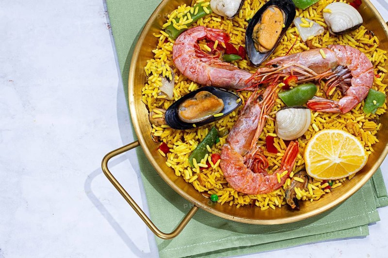Seafood paella, shrimp and mussel risotto, rice, paella in a pan, homemade, natural light, top view, no people