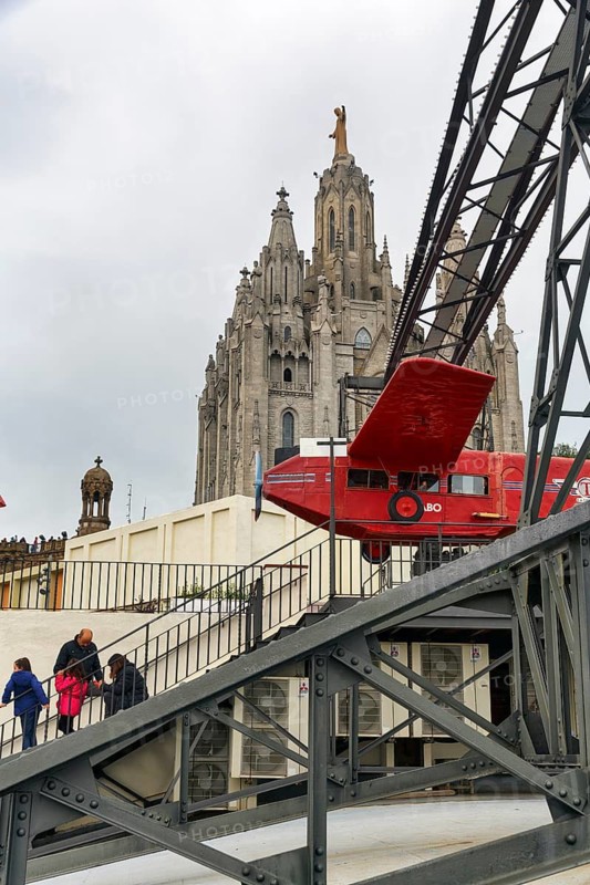 Red aeroplane, simulator, ride in front of church, Sagrat Cor, cloudy sky, Tibidabo amusement park, Barcelona, Spain
