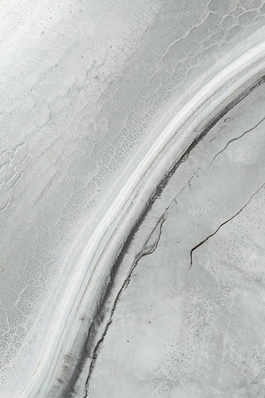 Aerial view of a saline mud landscape showcasing intricate patterns and textures. The unique formations highlight the beauty of nature's abstract artistry in a muted palette