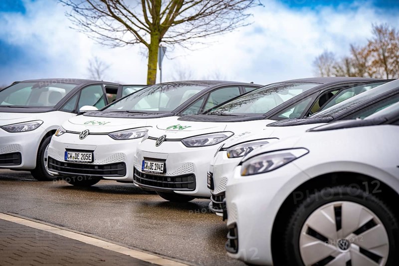 Several white electric vehicles park side by side on a street, Deer charging stations, Calw, Germany
