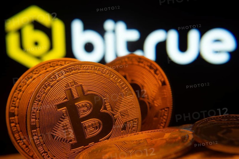 Dhaka, Bangladesh- 03 Sep 2025: Close-up of Bitcoin coins with the Bitrue logo visible on a screen in the background