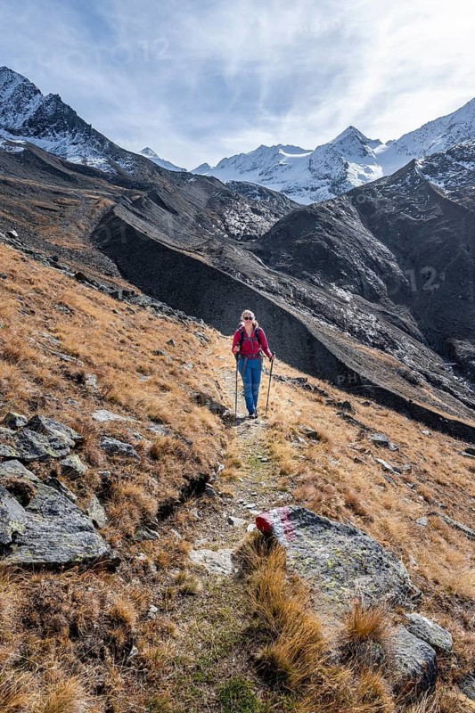 Mountaineer on a hiking trail in Niedertal, snow-covered mountain peaks of the Ötztal Alps with Finailspitze in the background, Ötztal Alps, Tyrol, Austria