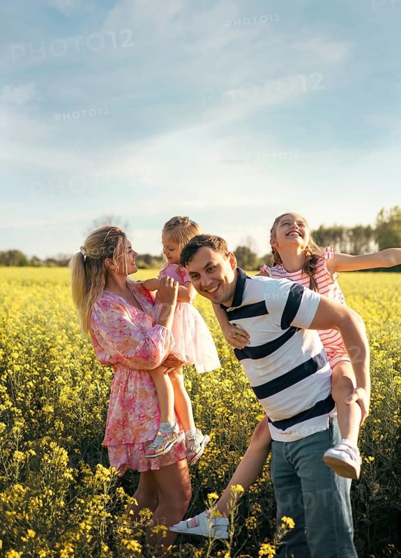 A family, mom, dad and two daughters are having fun together in nature. Family values