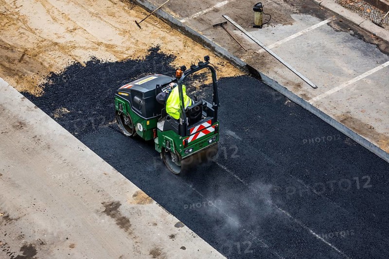 Tandem roller compacts an asphalt surface following road repair, Schöneberg, Berlin, Germany