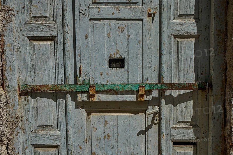 Old blue wooden door with a rusted latch in rustic style, Plaka, main town on Milos, Milos island, volcanic island, Cyclades, Greek Islands, Greece
