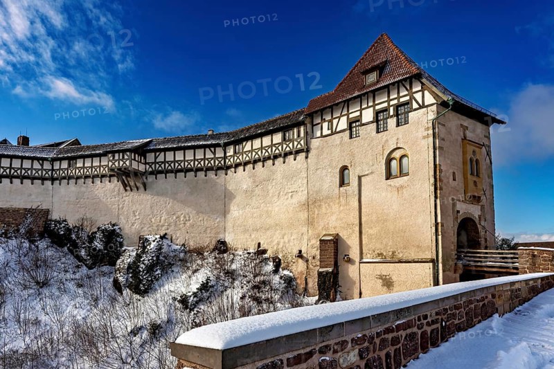 Winter view of a medieval castle with timber frame and snow-covered path in the foreground, The Wartburg near Eisenach in Thuringia