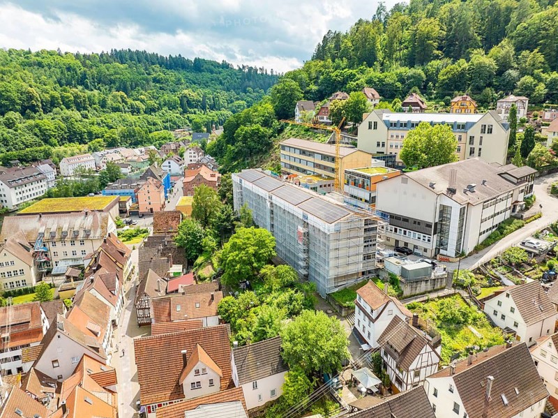 Urban landscape with hills rich in vegetation and dense buildings, new PV plant at Heinrich-Immanuel-Perrot secondary school, city of Calw, Germany